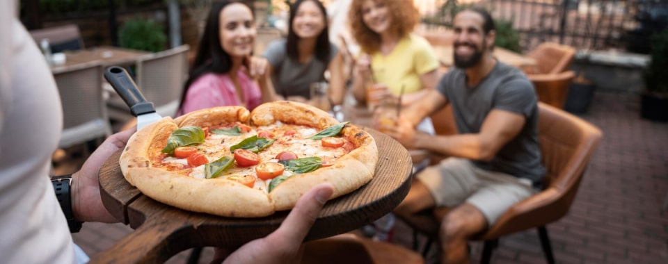 Restoranda pizza paylaşan arkadaş grubu